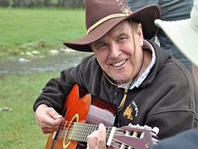 Mel playing guitar on the grass
